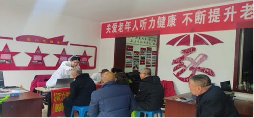 图为在义诊点医生在为老年人检查听力