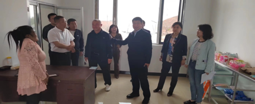 图为艾红锷（右三）与超市老板（左一）亲切交流
