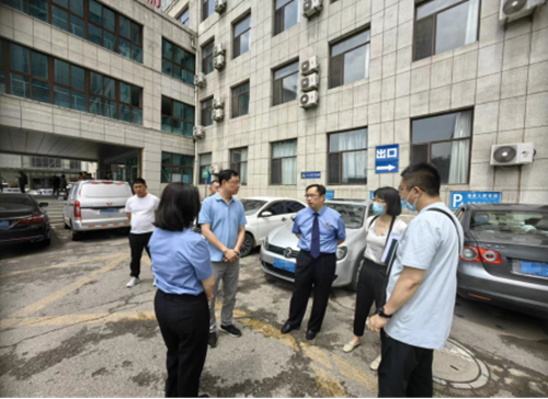 图为市检察院第四检察部主任张树勋（右三）与市残联副理事长于滨（右二）在调研现场探讨无障碍环境建设情况
